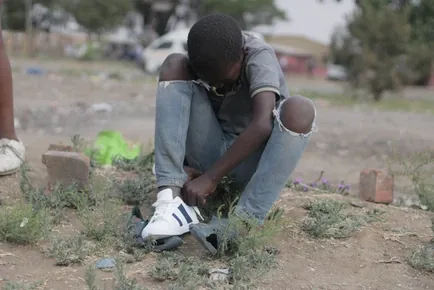 A child tying running shoes as part of Runmore with Ranmore